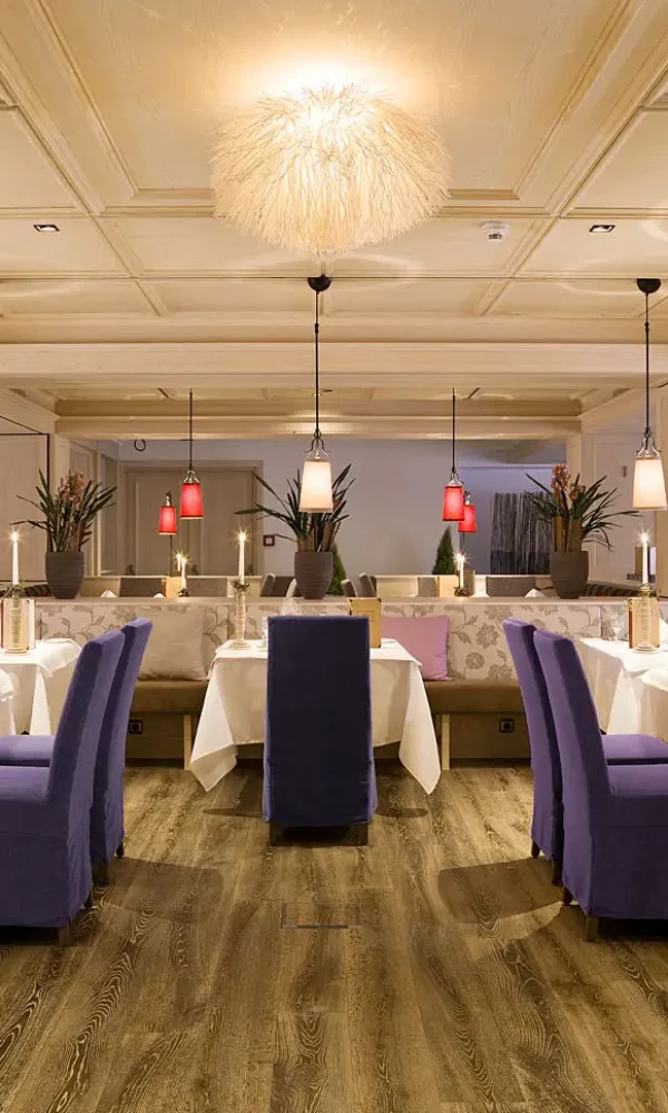 Elegant dining room with warm lighting, featuring a refined table setup at the Tirolerhof.